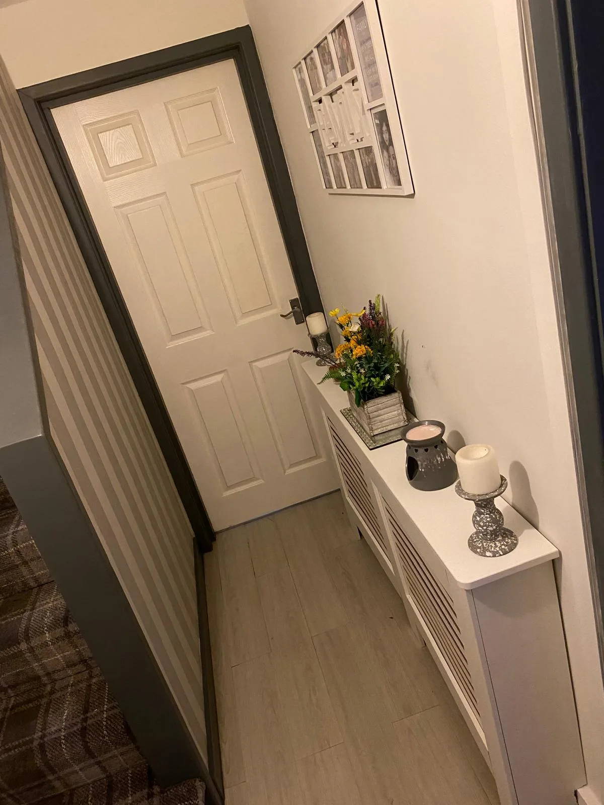 Decorated hallway with white panelled door and dark grey painted frame