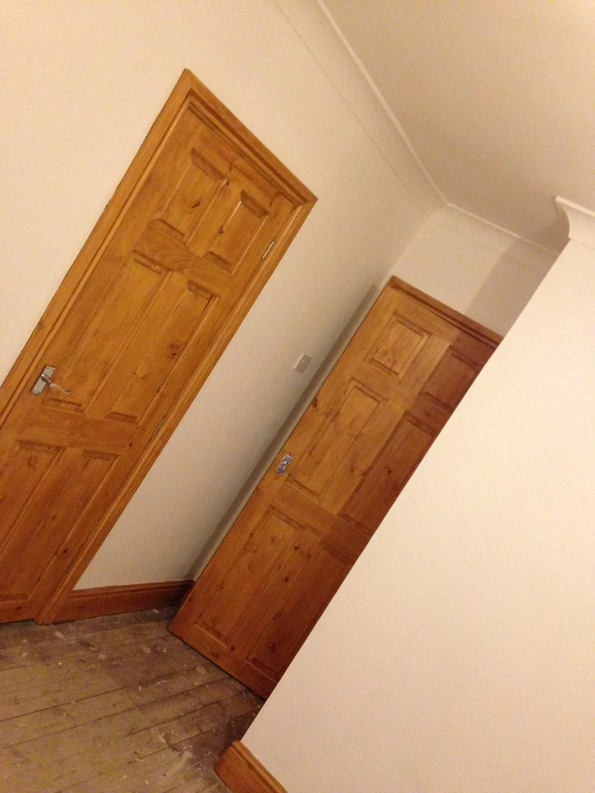 Freshly painted walls and ceiling around two panelled pine doors